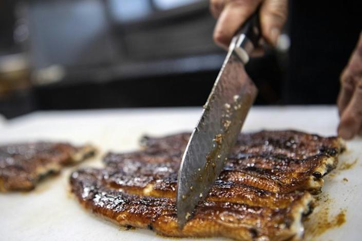 In this photo taken on April 16, 2021, Japanese chef Tsuyoshi Hachisuka slices grilled eel at his restaurant in Hamamatsu, Shizuoka prefecture. Photo: AFP