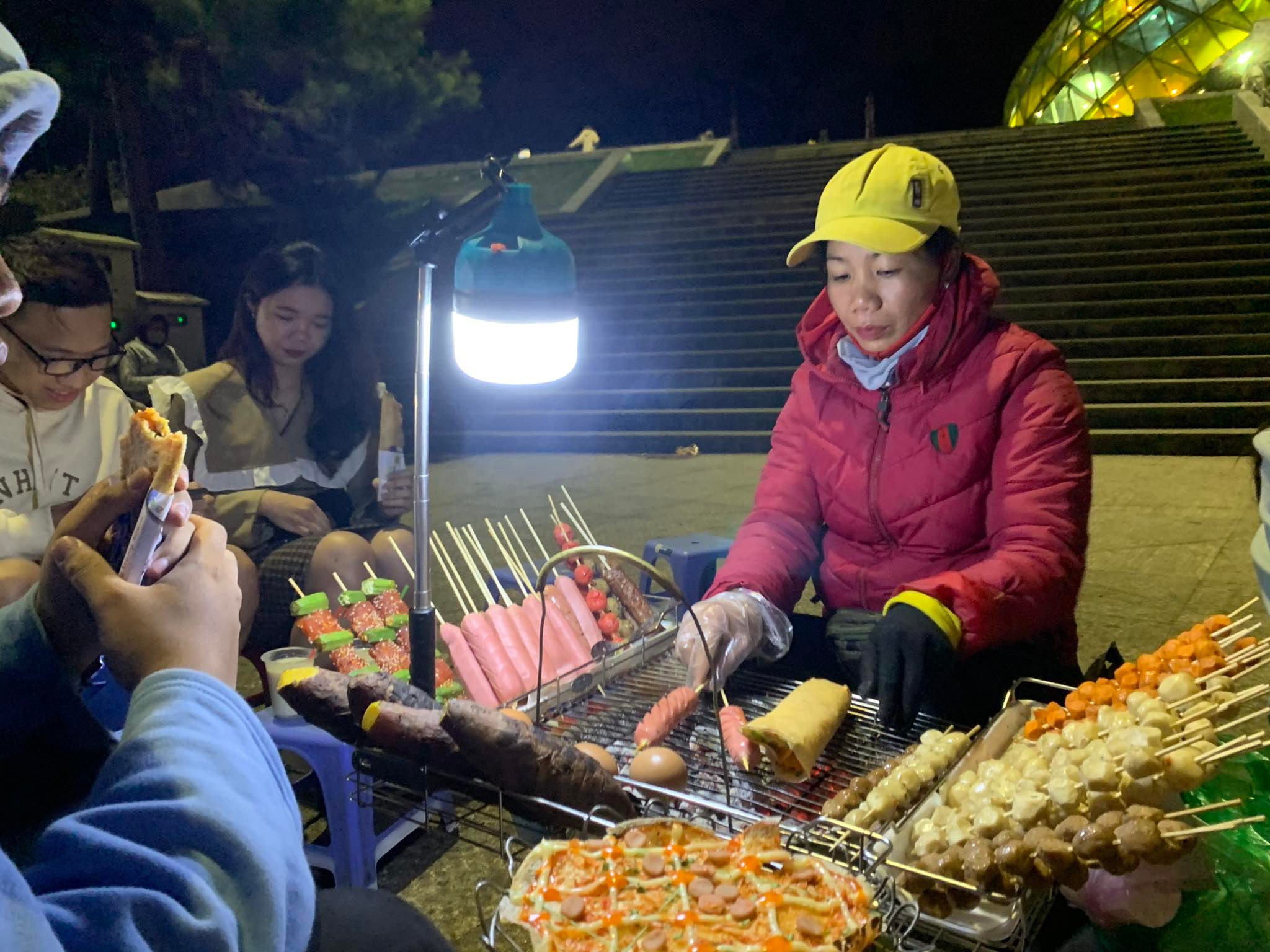 A street vendor sells 'banh trang nuong' with other grilled snacks at Lam Vien Square in the Central Highland City of Da Lat. Picture is taken in December 2020. Photo: Hoang An / Tuoi Tre News