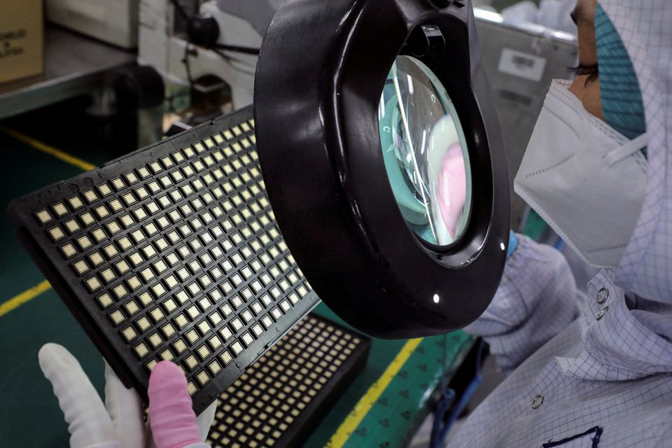 A worker inspects semiconductor chips at the chip packaging firm Unisem (M) Berhad plant in Ipoh, Malaysia October 15, 2021. Photo: Reuters