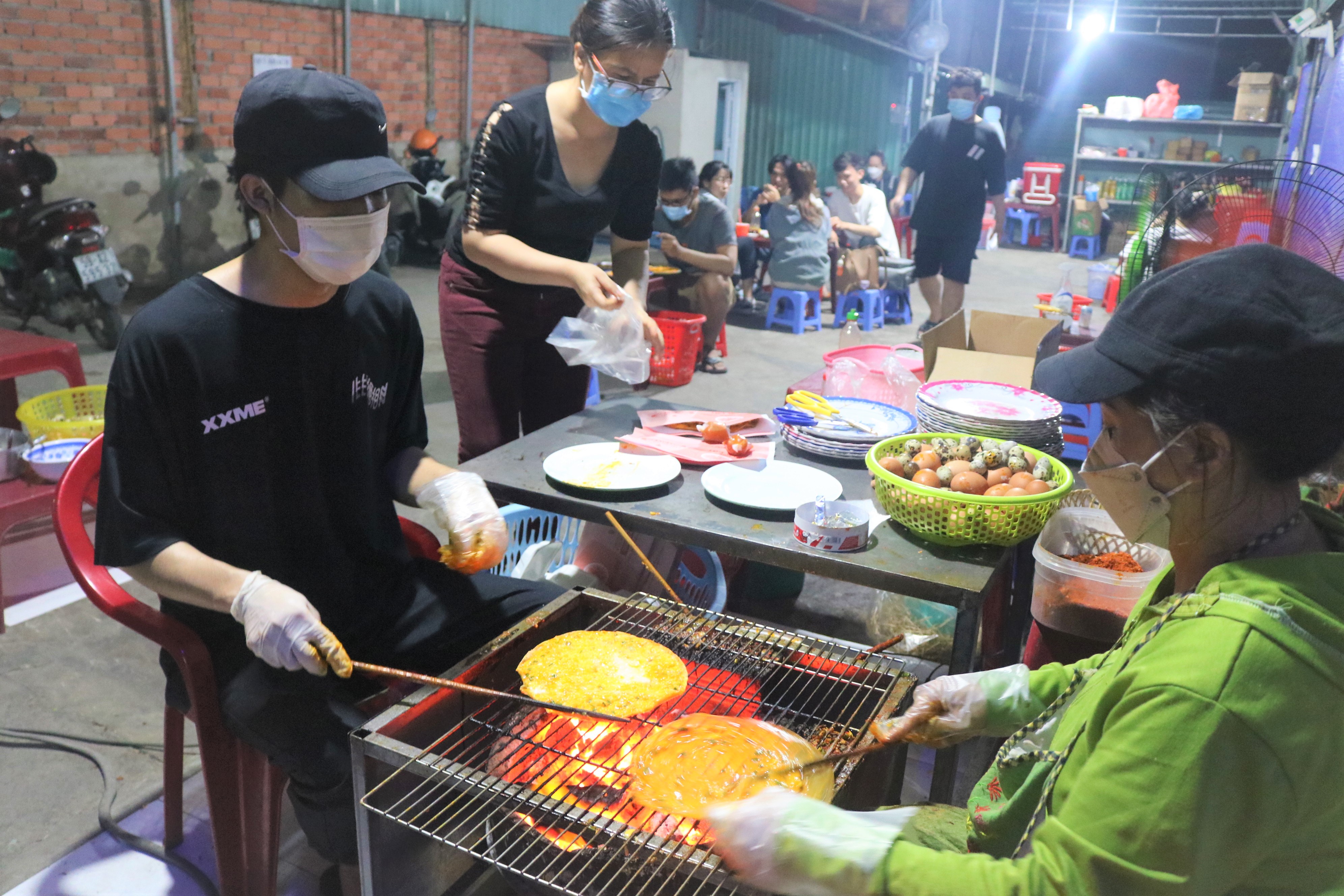 Staff is making 'banh trang nuong' at a stall in Thu Duc City in Ho Chi Minh City on December 14, 2021. Photo: Hoang An / Tuoi Tre News