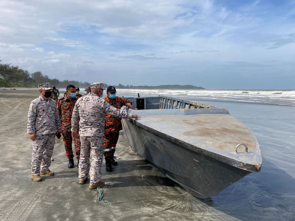Officials inspect a boat that capsized and killed some of the people onboard, while other migrants remain missing in Kota Tinggi, Johor state, Malaysia, December 15, 2021. Photo: Malaysia Maritime Enforcement Agency (MMEA)/Handout via Reuters