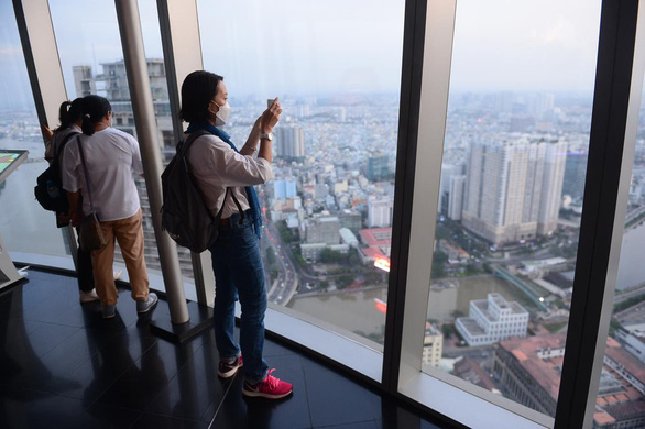 Visitors take photo of the city from the 49th floor of the Bitexco Financial Tower in District 1, Ho Chi Minh City, Vietnam, December 17, 2021. Photo: Quang Dinh / Tuoi Tre