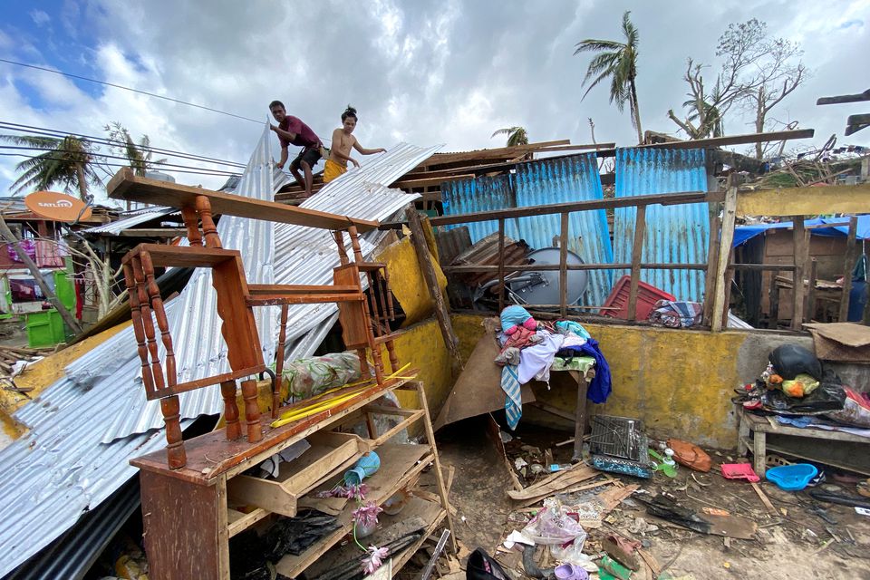 People rebuild a house damaged by typhoon Rai, in Surigao City, Surigao del Norte, Philippines, December 20, 2021. Picture taken December 20, 2021. Erwin Mascarinas/Greenpeace/Handout via Reuters