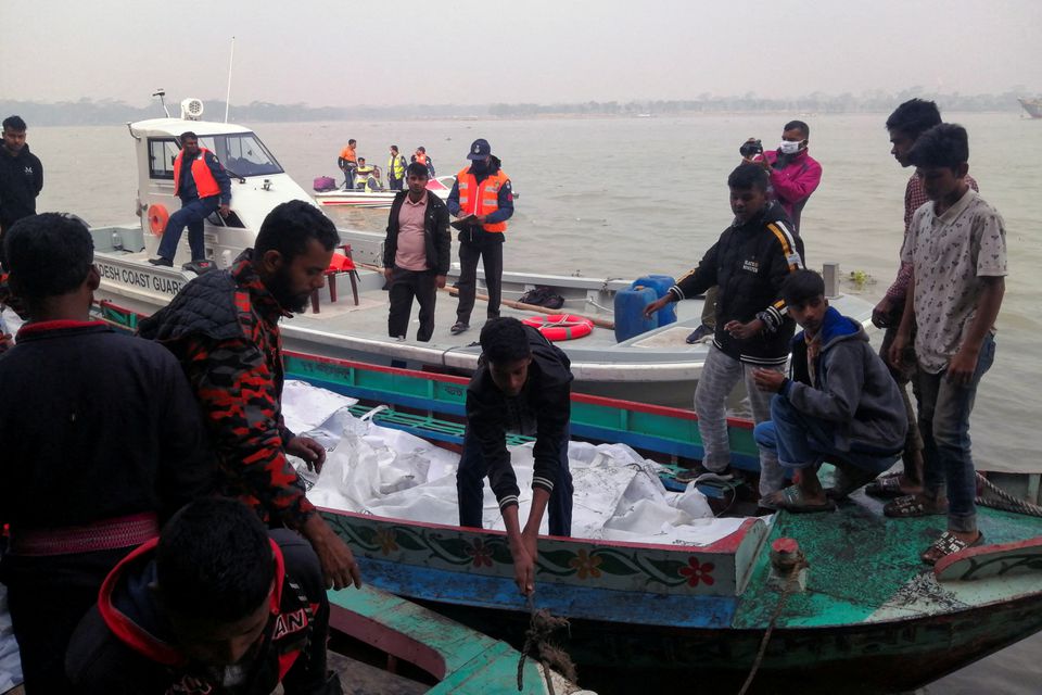 Rescue workers bring bodies on a boat, who died after a fire broke out in a passenger ferry on Sugandha River in Jhalalathi, Bangladesh, December 24, 2021. Photo: Reuters