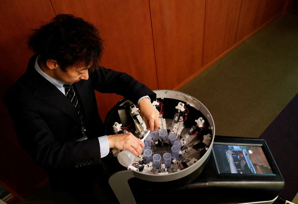 Meiji University professor Homei Miyashita fills flavour canisters as he demonstrates Taste the TV (TTTV), a prototype lickable TV screen that can imitate the flavours of various foods, at the university in Tokyo, Japan, December 22, 2021. Photo: Reuters