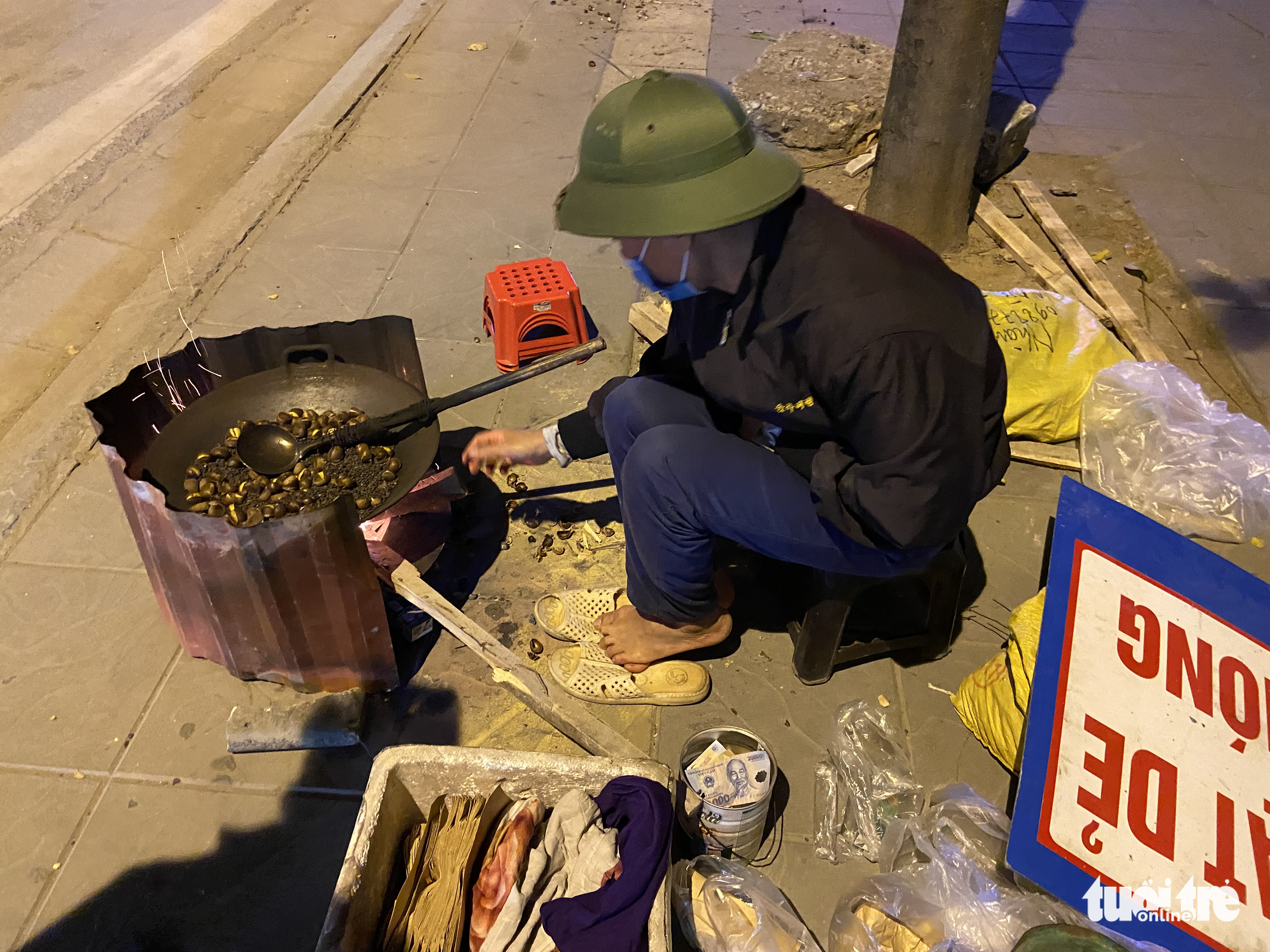 A man sells fried chestnuts on a sidewalk in Hanoi, December 27, 2021. Photo: Tuoi Tre