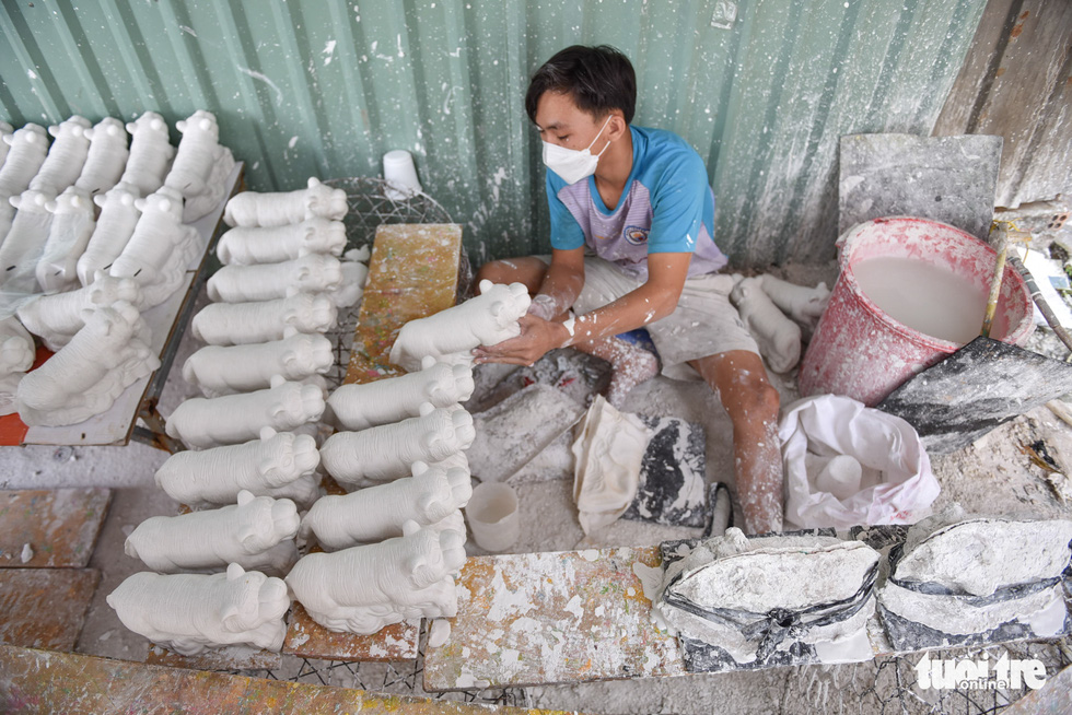 Artisan Nguyen Nhat Hao pours plaster into a tiger mold at a workshop in Lai Thieu Ward, Thuan An City, Binh Duong Province. Photo: Ngoc Phuong / Tuoi Tre