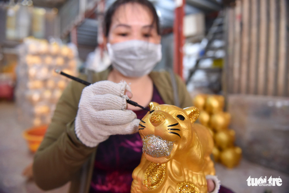 Artisan Vo Thi Thanh Ha adorns a gold-plated plaster tiger in Lai Thieu Ward, Thuan An City, Binh Duong Province. Photo: Ngoc Phuong / Tuoi Tre