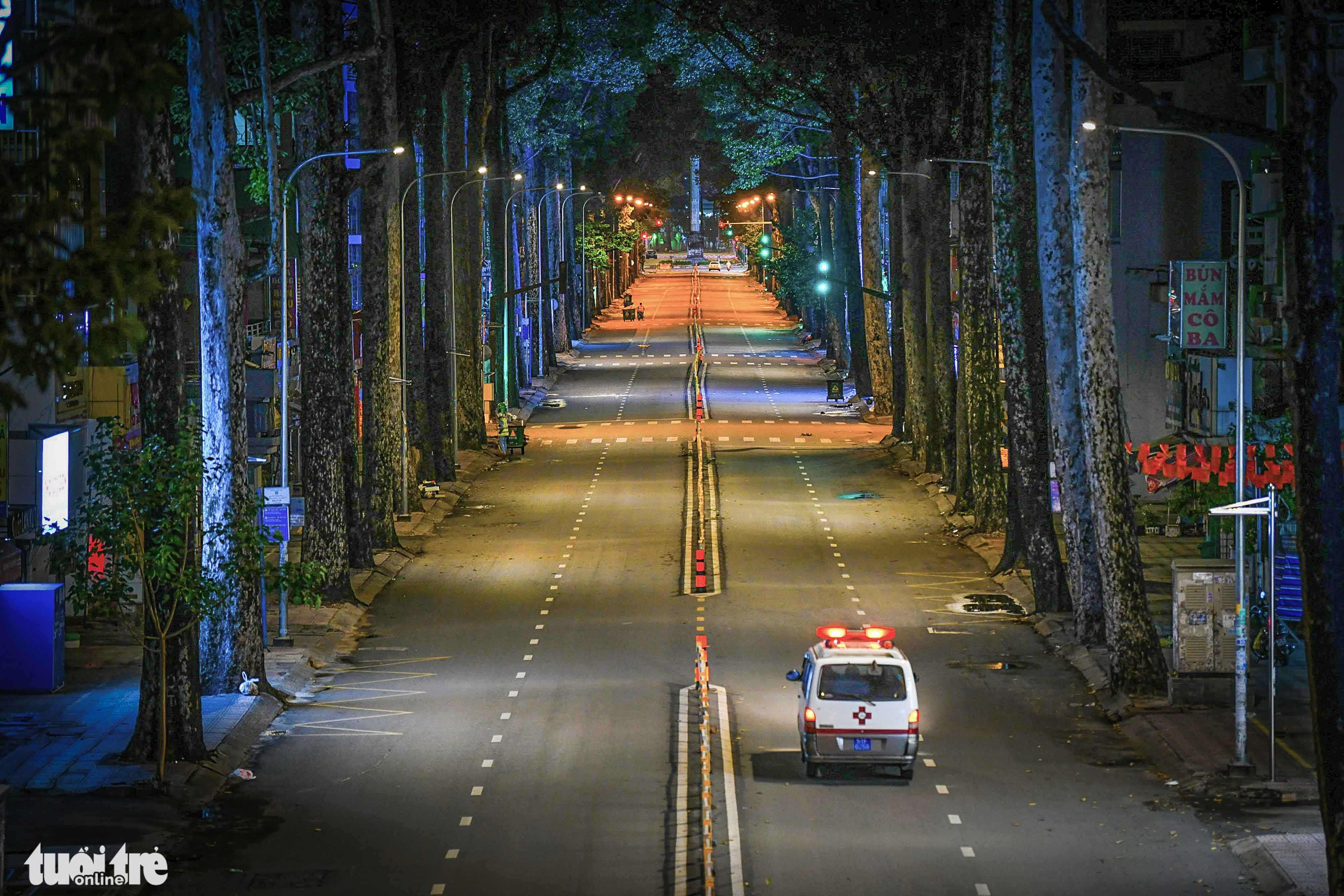 An ambulance travels along an empty street in District 10, Ho Chi Minh City at 7:00 pm on July 27, 2021, after municipal authorities began enforcing a moment restriction order after 6:00 pm to curb the pandemic. Photo: Quang Dinh / Tuoi Tre