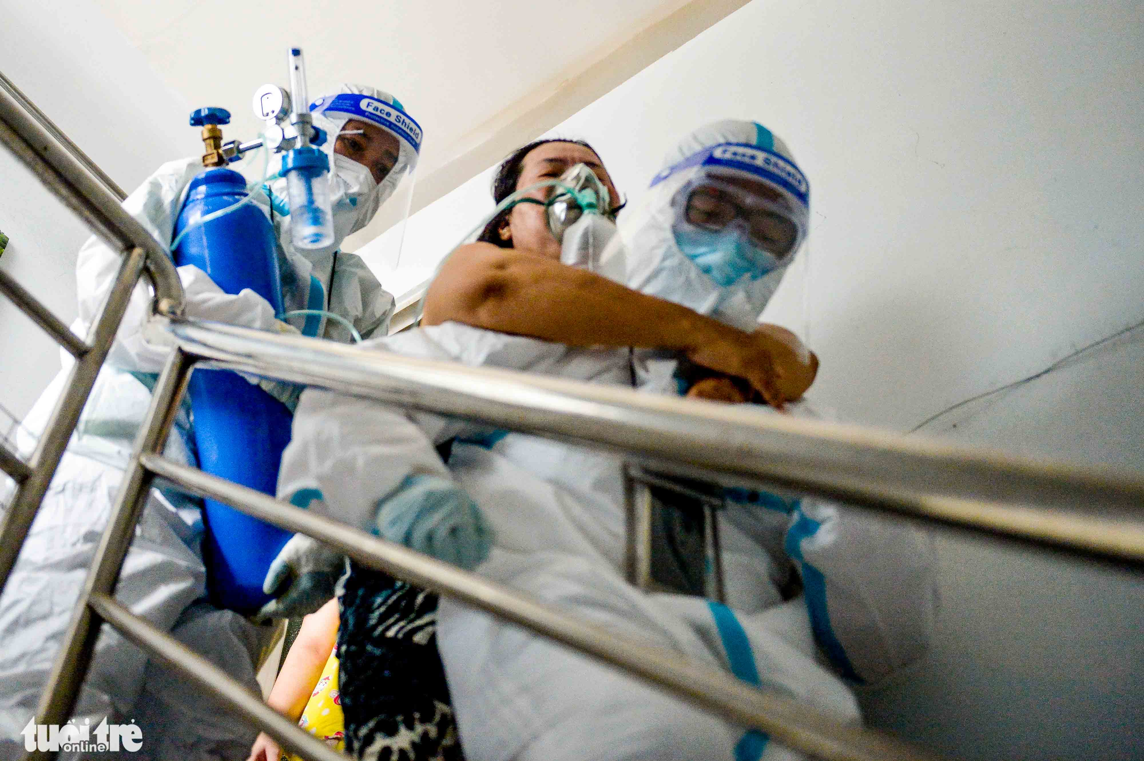 Health workers take a COVID-19 patient who is suffering from difficulty breathing to the hospital in Nha Ba District, Ho Chi Minh City. Tu Trung / Tuoi Tre