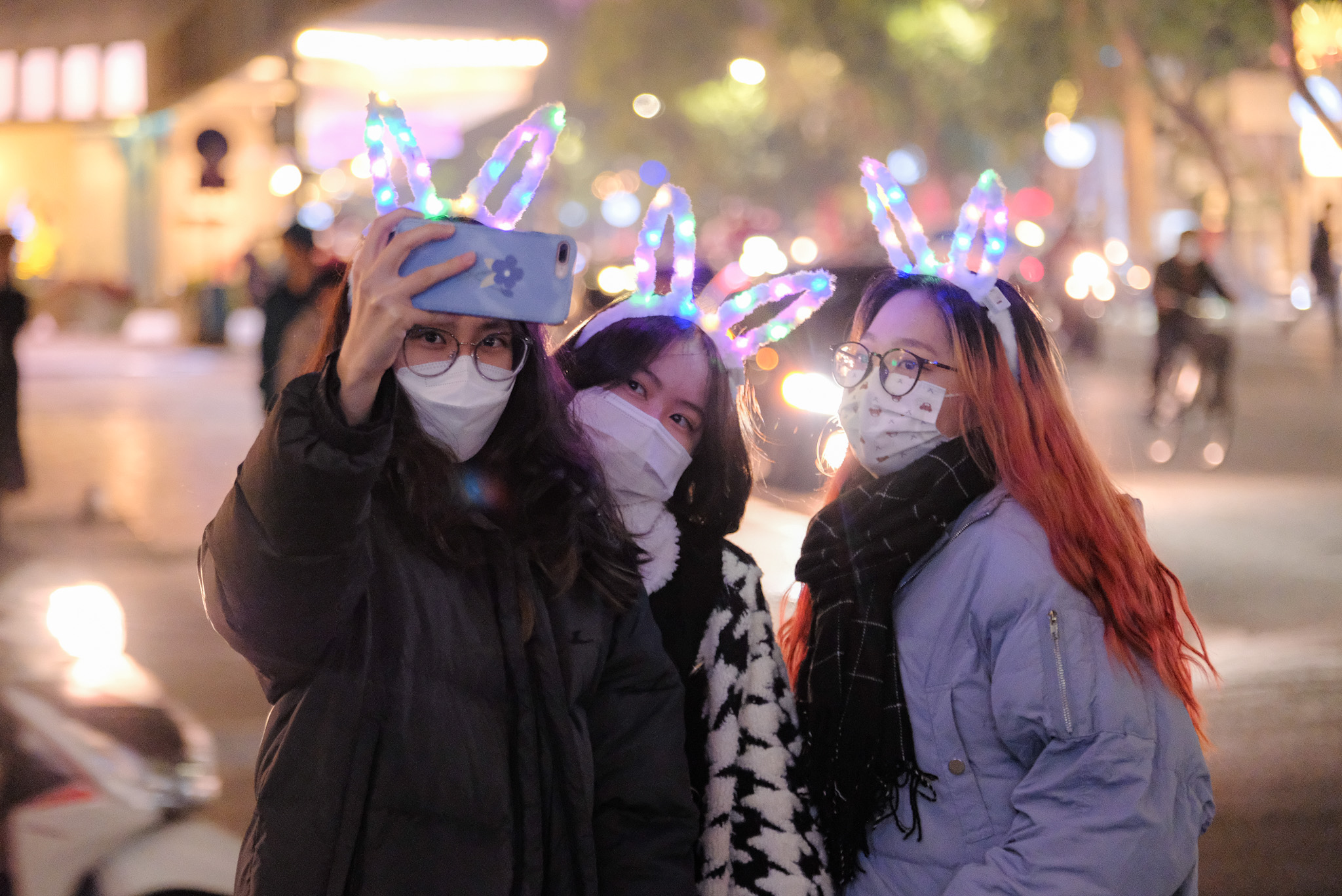 Three young people take a photo on Dinh Tien Hoang Street in Hanoi on the night of December 31, 2021. Photo: Tuoi Tre