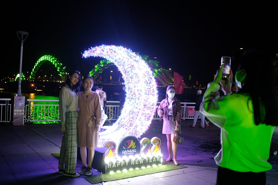 People take photos next to a light display in Da Nang City on the night of December 31, 2021. Photo: Tuoi Tre