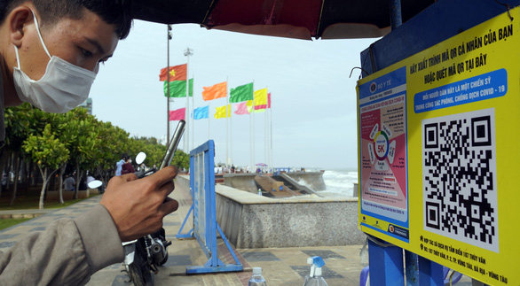 A man scans QR code for medical declaration to prevent COVID-19 at Bai Sau beach in the southern city of Vung Tau on the afternoon of January 2, 2022. Photo: Dong Ha / Tuoi Tre