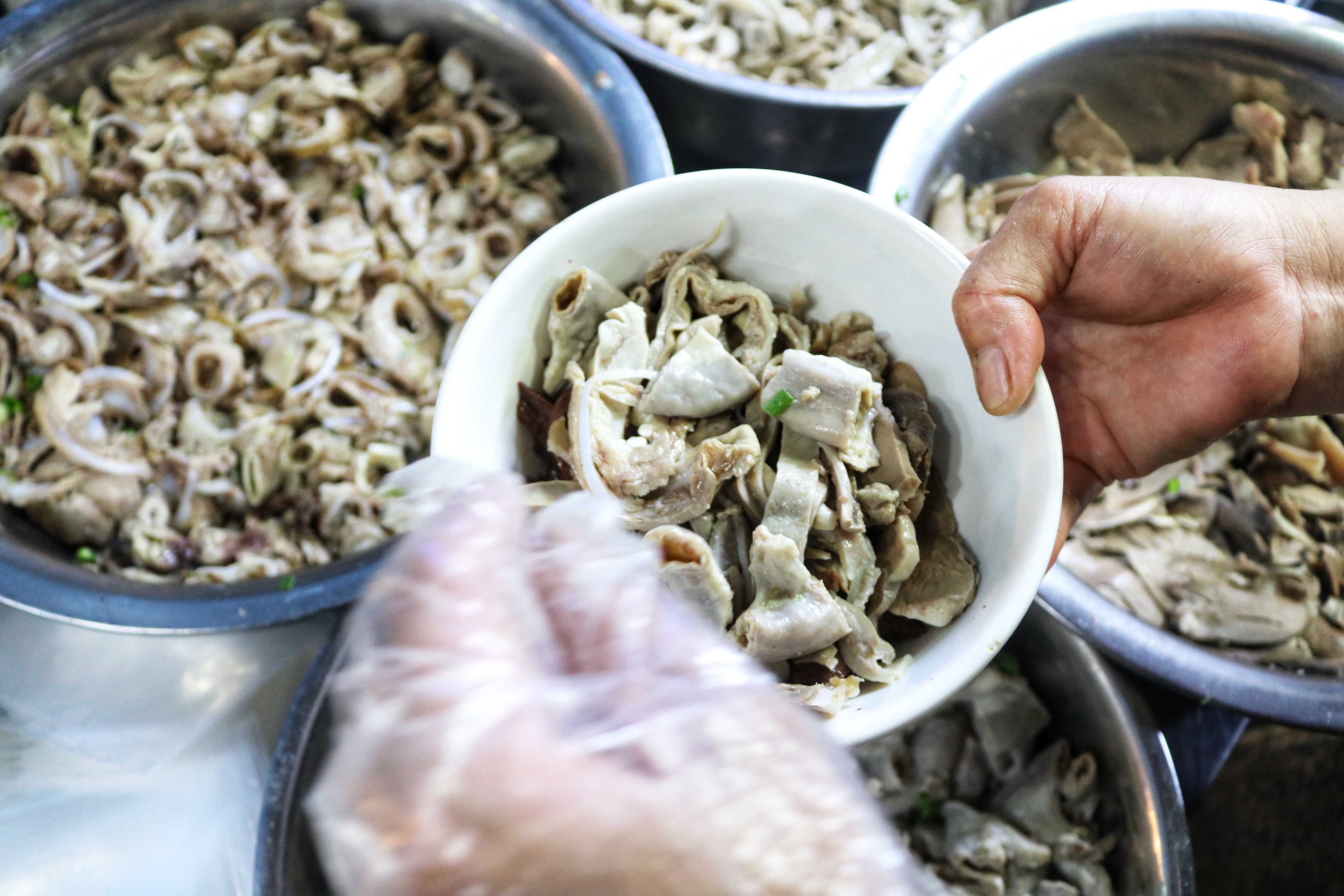 Cooked pig organs are put in a bowl to be served at Hoa’s stall on Pham Van Hai Street in Tan Binh District, Ho Chi Minh City. Photo: Hoang An / Tuoi Tre News