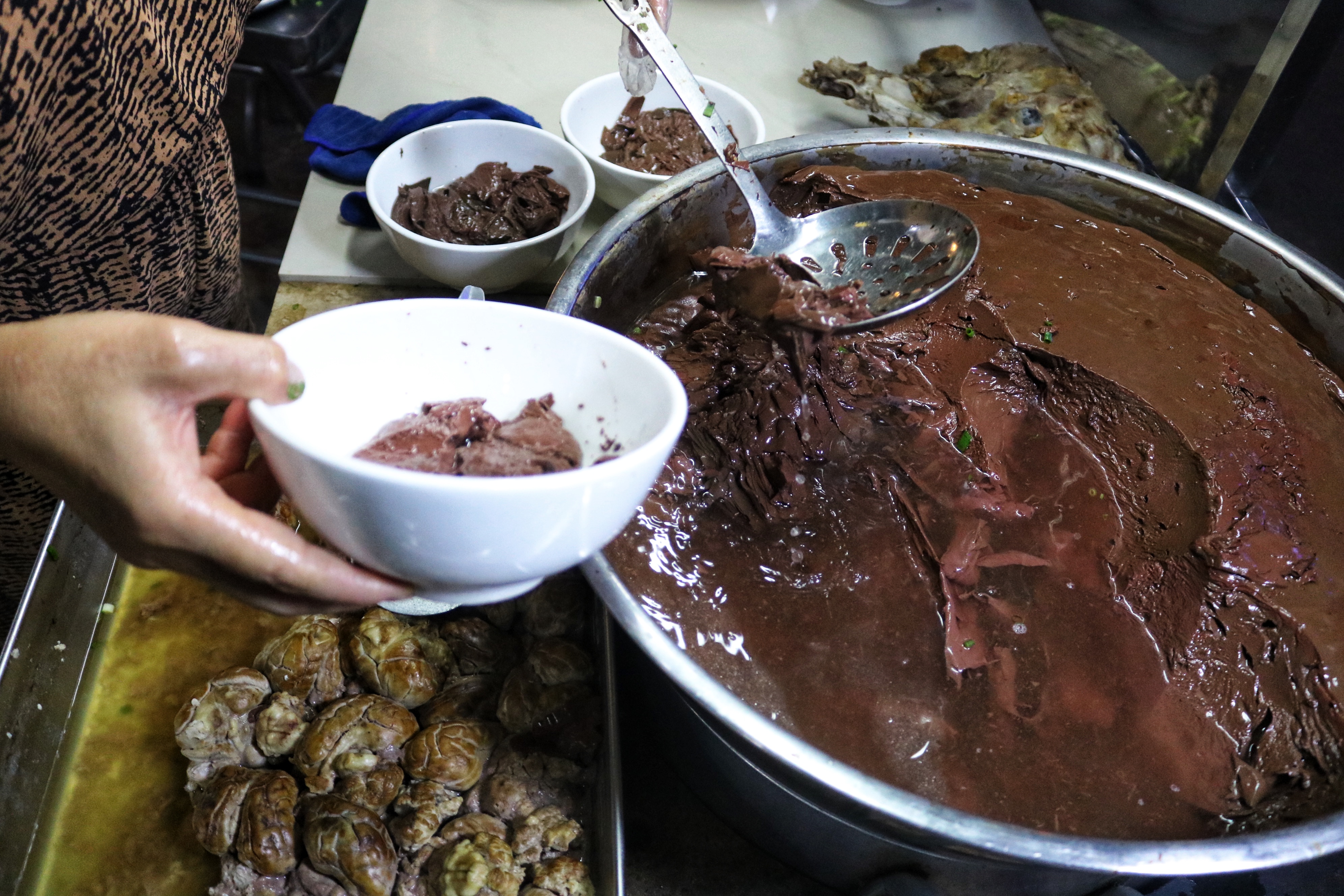 Pham Thi Hoa scoops blood pudding to serve diners at her stall on Pham Van Hai Street in Tan Binh District, Ho Chi Minh City. Photo: Hoang An / Tuoi Tre News