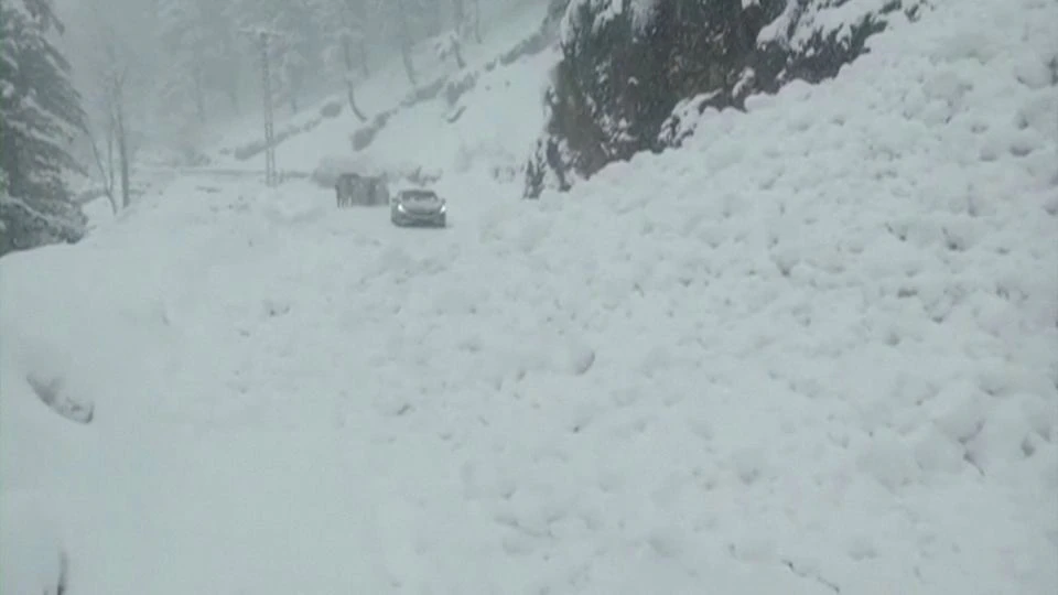 Vehicles are seen on a snowy road, in Murree, northeast of Islamabad, Pakistan in this still image taken from a video January 8, 2022. Photo: PTV/REUTERS TV via REUTERS