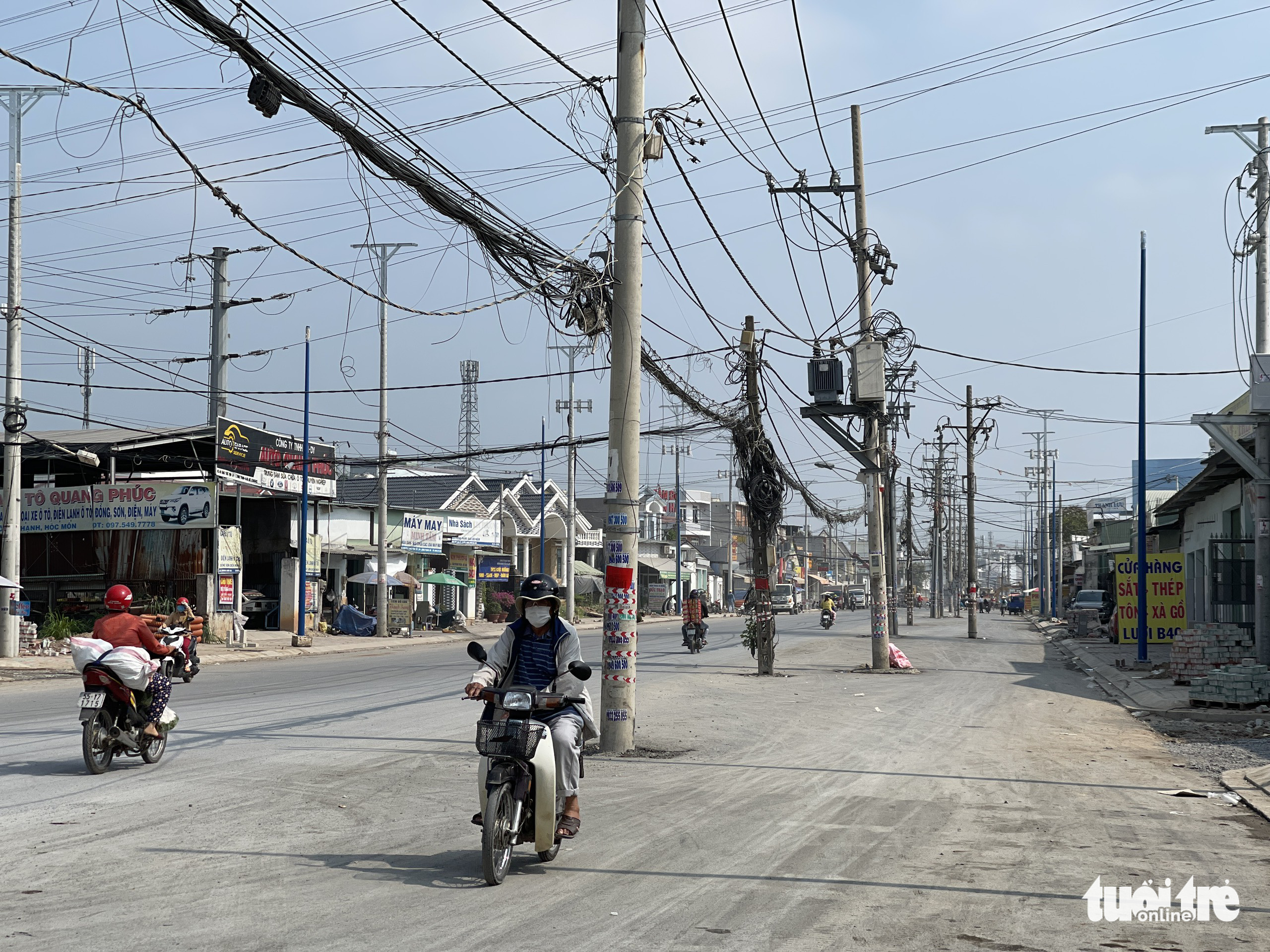 Power poles stand in the middle of Dang Thuc Vinh Street in Hoc Mon District, Ho Chi Minh City. Photo: Le Phan / Tuoi Tre