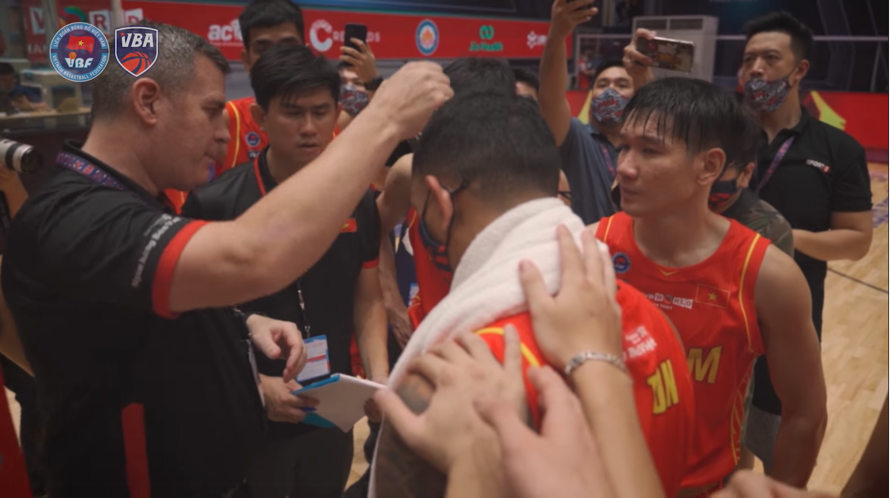 Coach Kevin Yurkus (L) of the Vietnamese national basketball team discusses the strategy with his athletes. Photo: VBA