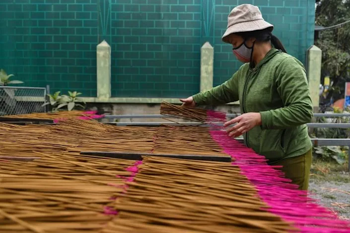 A worker collects dried incense sticks for sale. Photo: AFP