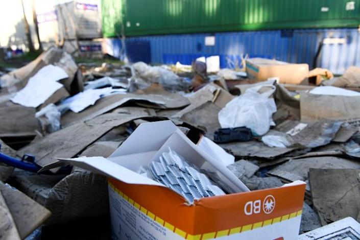 An open box of unused Covid-19 tests is left behind on a section of Union Pacific train tracks littered with thousands of opened boxes and packages stolen from cargo shipping containers, targeted by thieves as the trains stop in downtown Los Angeles. Photo: AFP