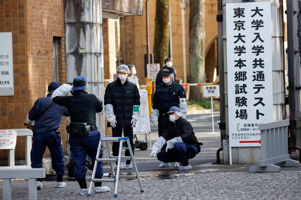 Police officers inspect the site where a stabbing incident happened at an entrance gate of Tokyo University in Tokyo, Japan January 15, 2022. Photo: Reuters