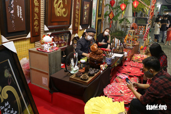Festival goers are seen at a calligraphy stall at the festival. Photo: Hoang An / Tuoi Tre