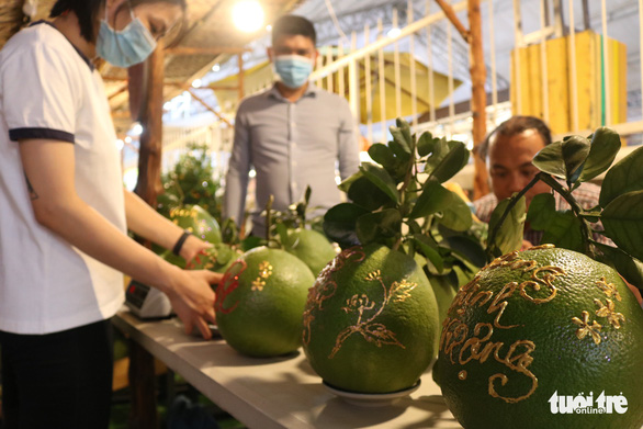 This photo shows a booth of an artisan who perform calligraphy on pomelos at the festival. Photo: Hoang An / Tuoi Tre