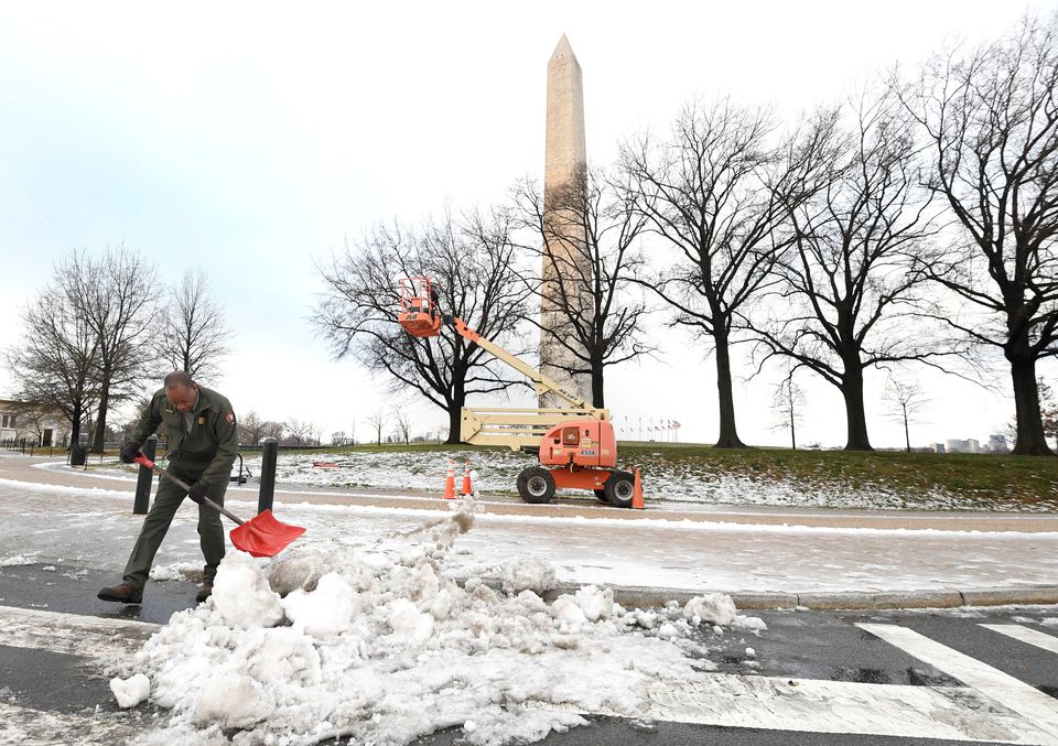A National Park Service worker shovels snow near the Washington Monument after a stormy night, in Washington, U.S., January 17, 2022. Photo: Reuters