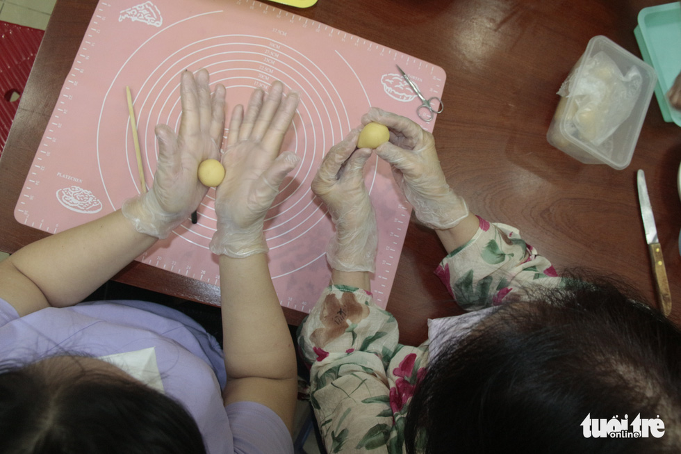 A student and her instructor practice forming cakes from green bean paste. Photo: Cong Trieu / Tuoi Tre