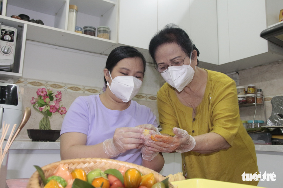 Culinary artist Nguyen Thi Phien (right) instructs a student how to make a fruit-shaped cake. Photo: Cong Trieu / Tuoi Tre