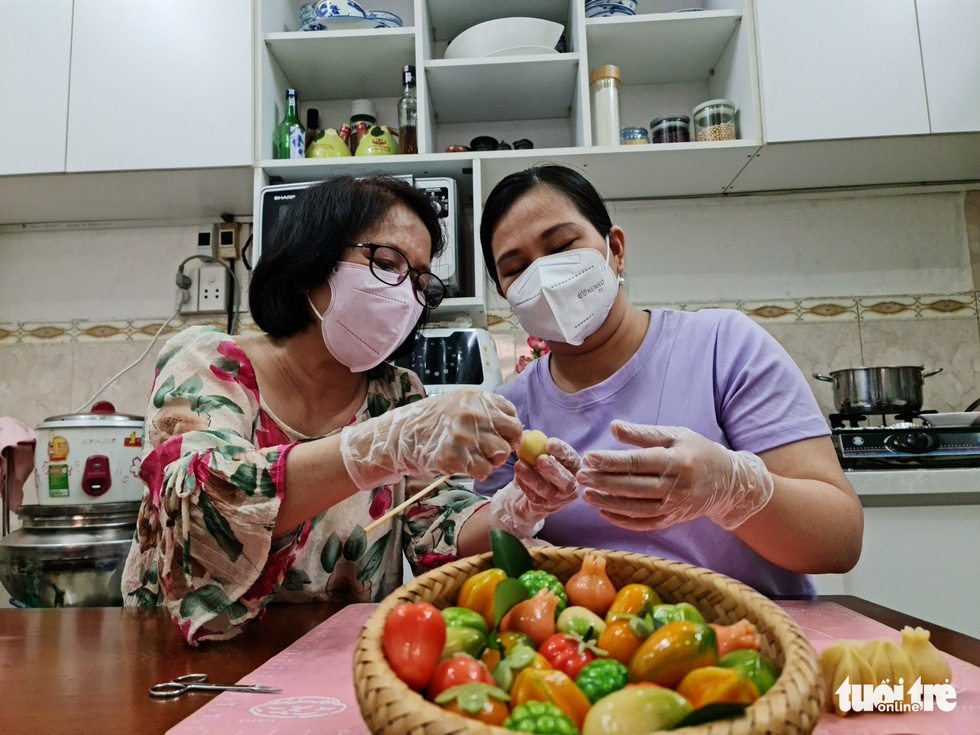 Do Thi Phuong Nhi (left) instructs a student how to make a fruit-shaped cake. Photo: Cong Trieu / Tuoi Tre