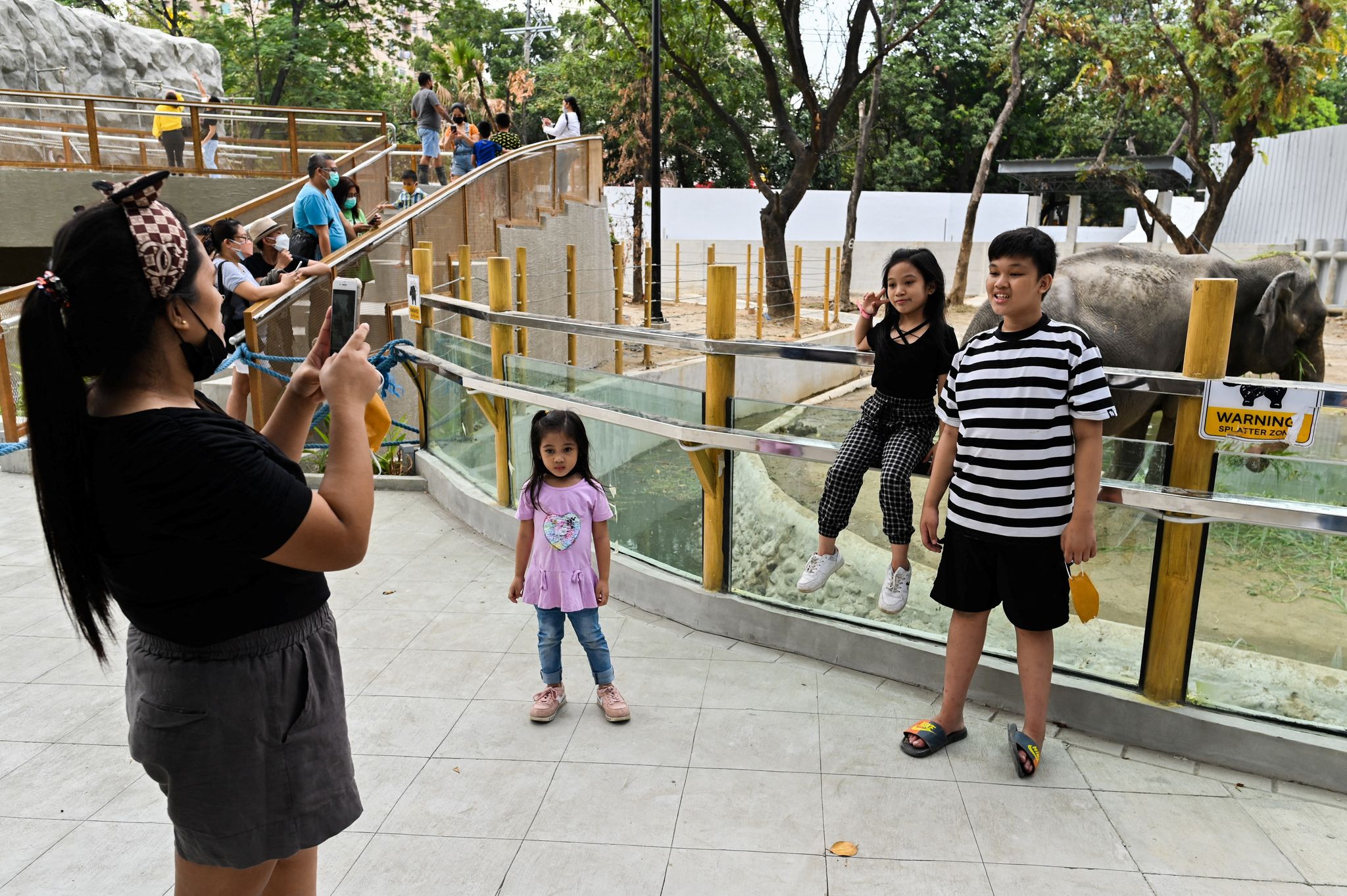 A woman takes picture with her phone as people visit Manila Zoo, which serves as a coronavirus disease (COVID-19) vaccination site, in Manila, Philippines, January 19, 2022. Photo: Reuters