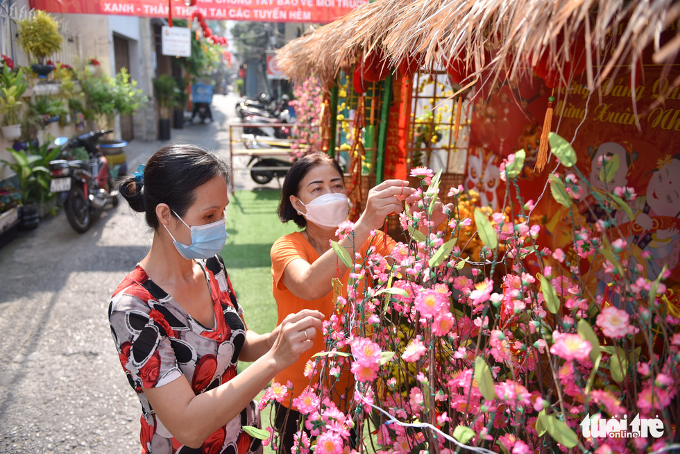 Tran Thi Hanh (right) and Nguyen Ngoc Phuong Lien are working on Tet decorations at Alley No.153 on Nguyen Thi Minh Khai Street in District 1, Ho Chi Minh City, January 2022. Photo: Ngoc Phuong / Tuoi Tre