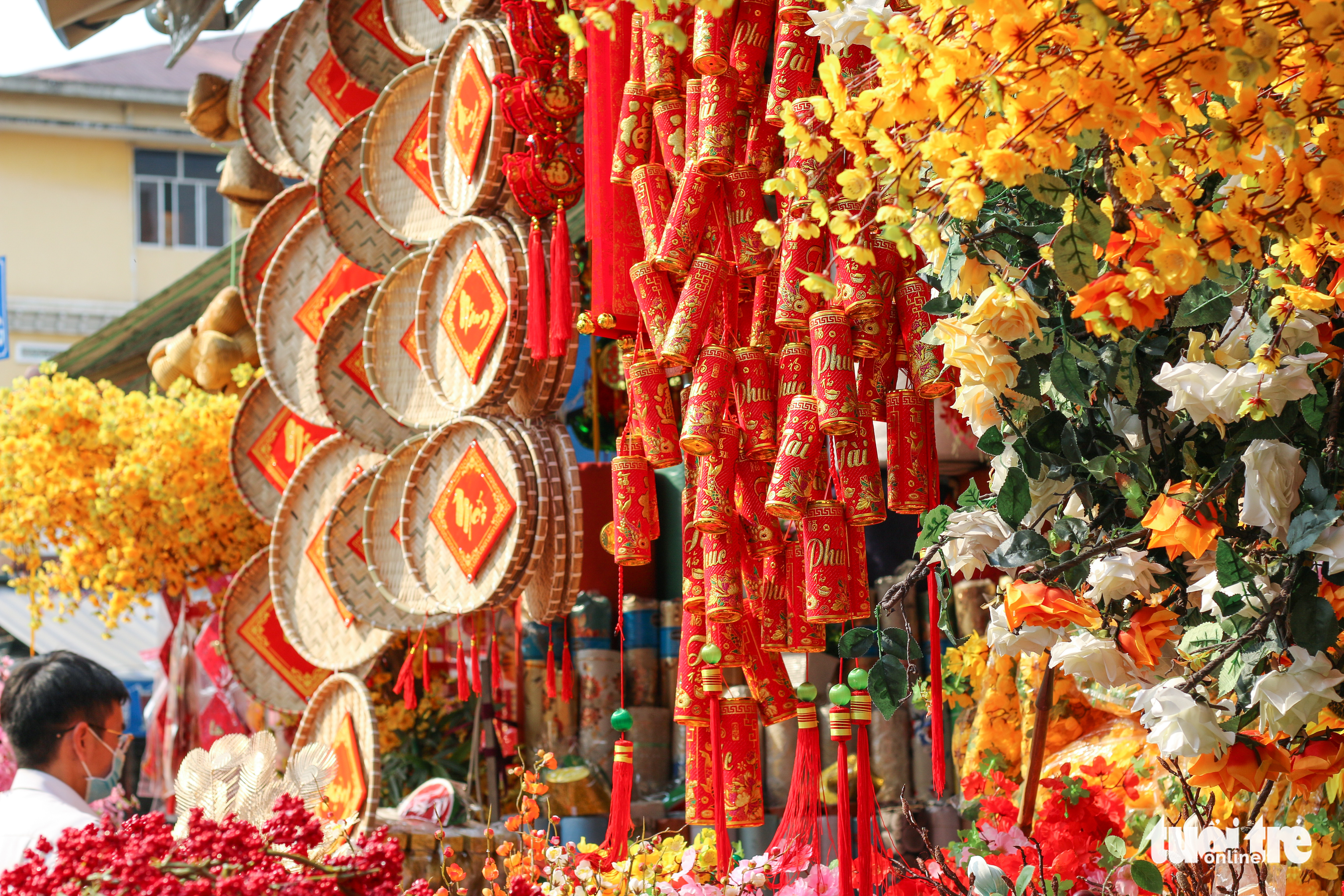 A shop sells red couplets, paper cannons, and artificial apricots and peach blossoms at 'Tai loc' Market on Hai Thuong Lan Ong Street in District 5, Ho Chi Minh City. Photo: Chau Tuan / Tuoi Tre