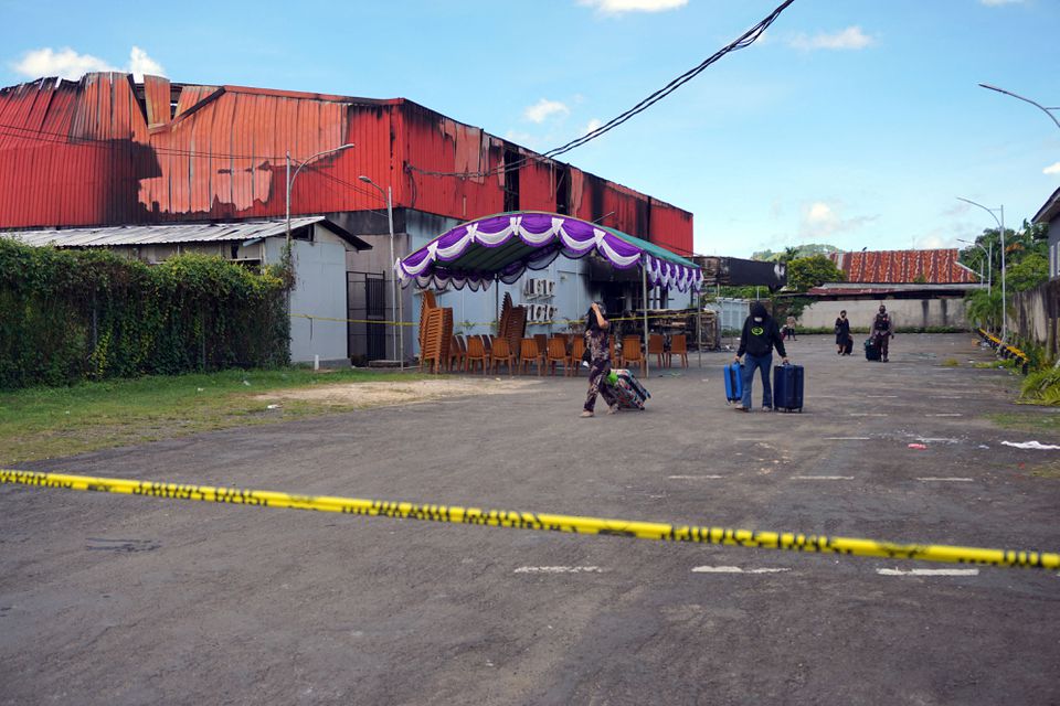 Workers of Double O Karaoke bar leaves the entertainment outlet which was set ablaze following a brawl between rival gangs of youths in West Papua, Indonesia, January 25, 2022 in this photo taken by Antara Foto. Photo: Antara Foto via Reuters
