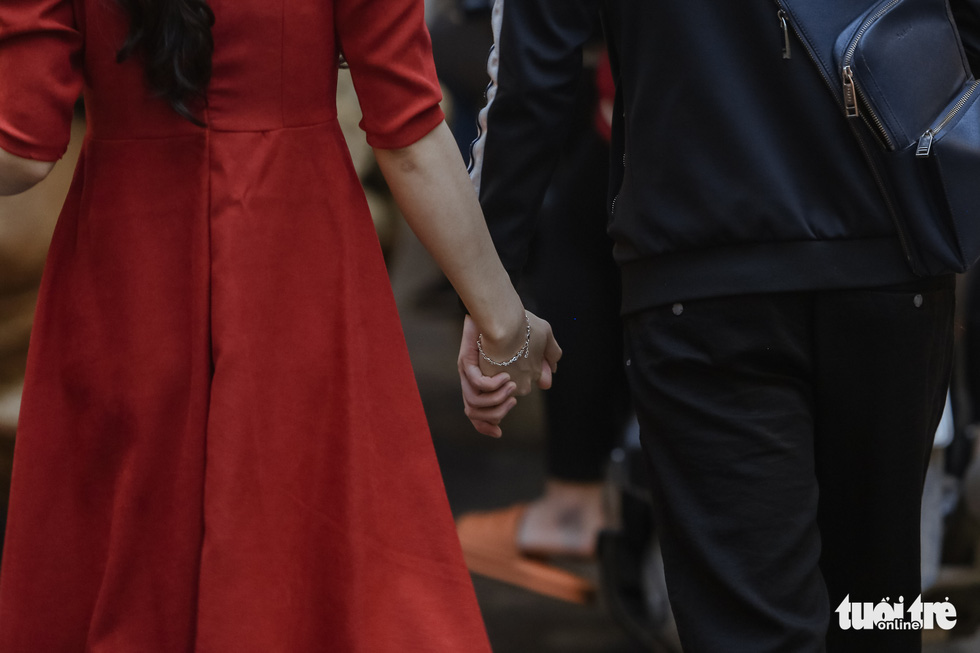A couple walks hand in hand among the crowd at the Hang Luoc Market in Hoan Kiem District, Hanoi. Photo: Ha Quan / Tuoi Tre