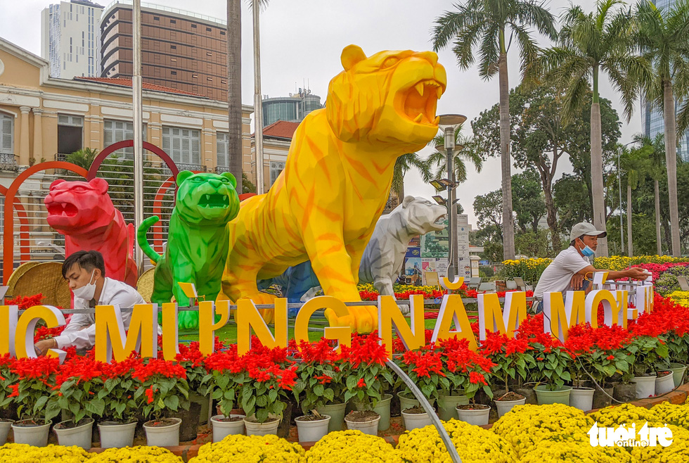 Workers rush to complete the flower street and tiger models on Bach Dang Street in Da Nang, Vietnam, January 25, 2022. Bach Dang Flower Street is adorned this year with a model of five tigers in five different hues, representing the five elements. Photo: Tan Luc / Tuoi Tre