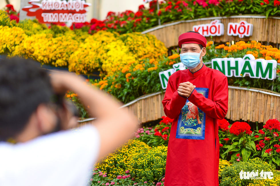 An elderly patient poses in his traditional red Ao Dai.