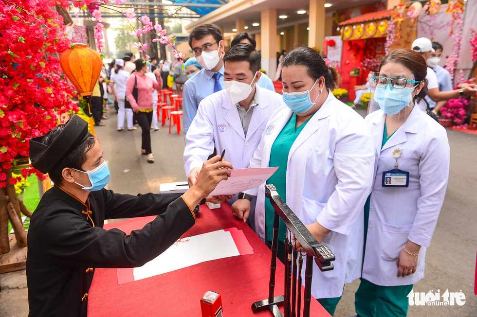 A calligraphy artist is seen handing lucky wishes to medical workers at Cho Ray Hospital.