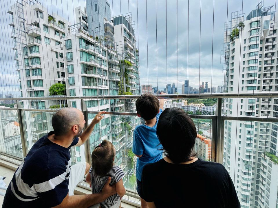 Israeli expatriate Atar Sandler, 35, and her husband speak to their children at the balcony of their apartment in central Singapore, overlooking the skyline of the Southeast Asian financial hub January 8, 2022. Photo: Reuters