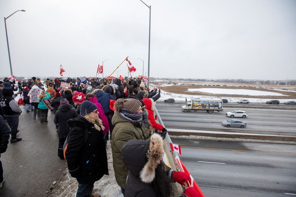 Supporters of truckers gather on a highway overpass in Toronto, Ontario, Canada, to support truck drivers on their way to Ottawa to protest coronavirus disease (COVID-19) vaccine mandates for cross-border truck drivers January 27, 2022. Photo: Reuters