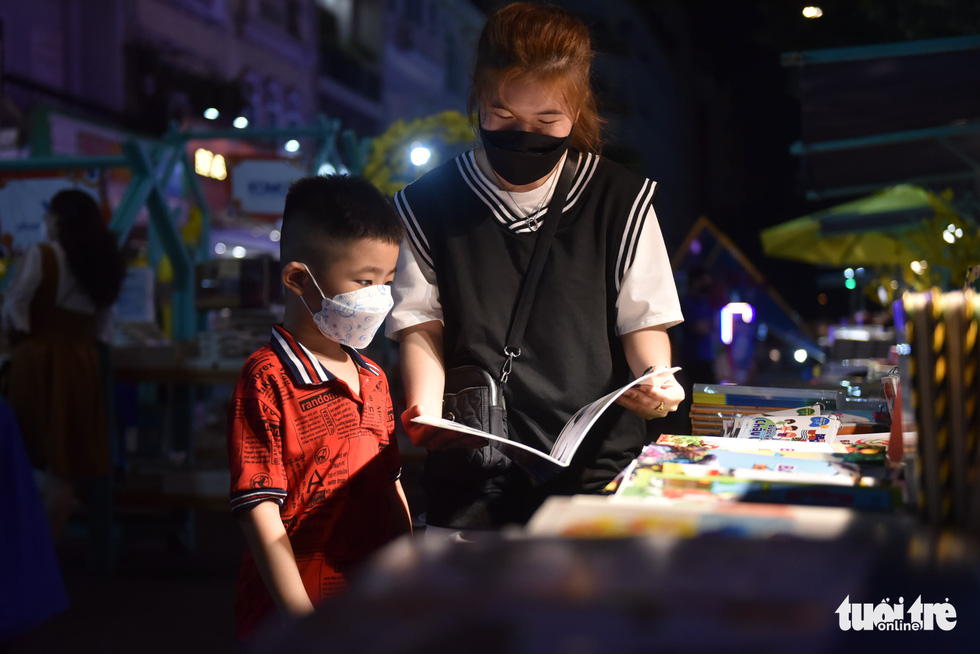 A woman and a boy read books at the 2022 Lunar New Year's book street festival in District 1, Ho Chi Minh City, January 29, 2022. Photo: Tuoi Tre