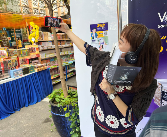 A young woman takes a selfie photo at the Lunar New Year's book street festival on Nguyen Van Binh Street, District 1, Ho Chi Minh City, January 30, 2022. Photo: Tuoi Tre
