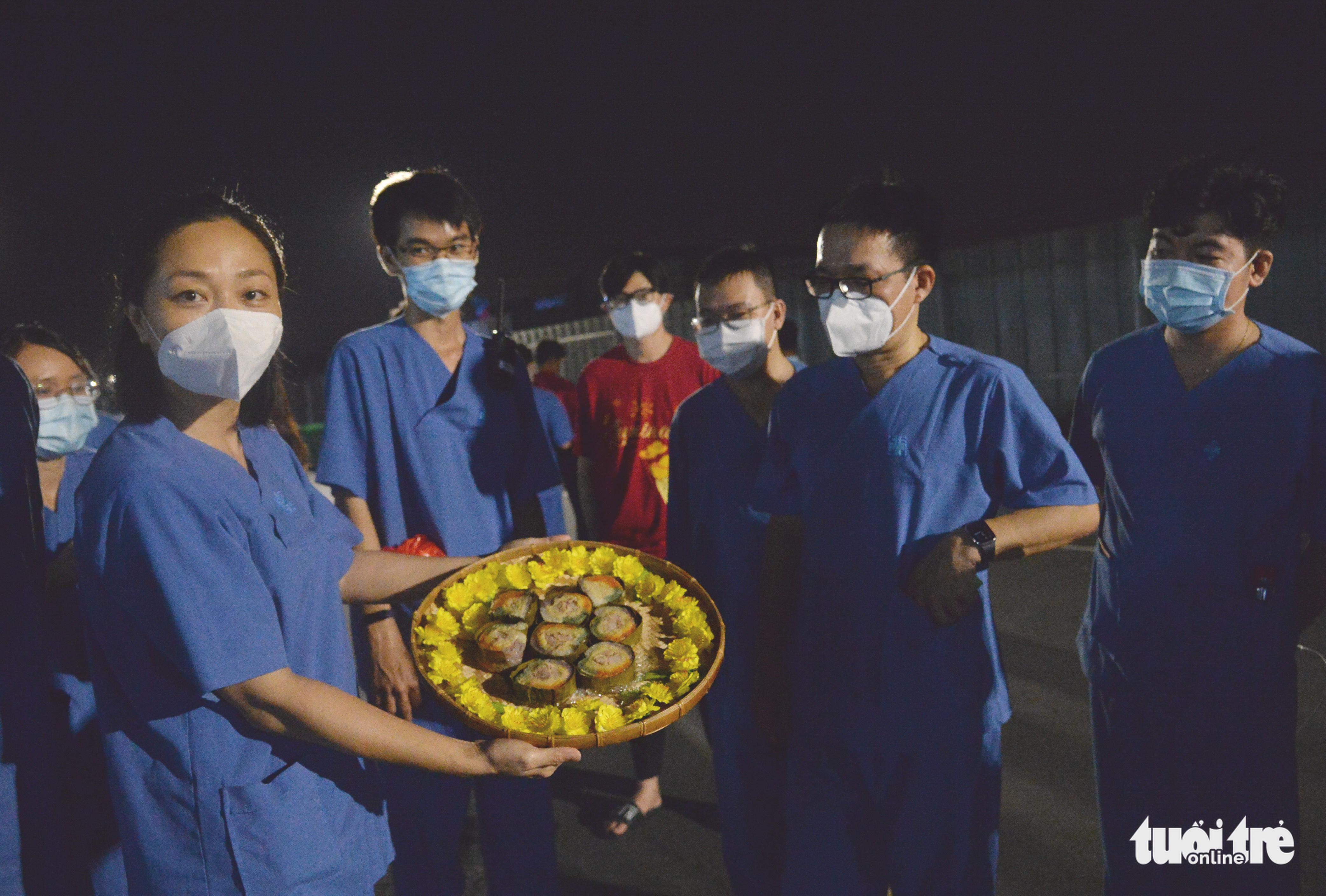 Health workers show the banh tet they have cooked. Photo: Tu Trung / Tuoi Tre
