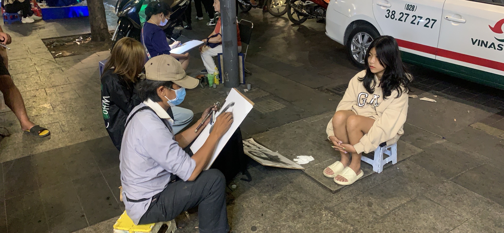 A street artist draws a portrait of a young woman on Nguyen Hue Walking Street in District 1, Ho Chi Minh City, January 31, 2022. Photo: T.T.D. / Tuoi Tre