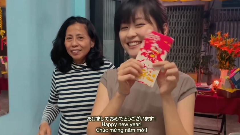 Akari Nakatani (right) smiles while receiving lucky money during Tet holiday in 2021 in a screenshot captured from a video she posted on YouTube.