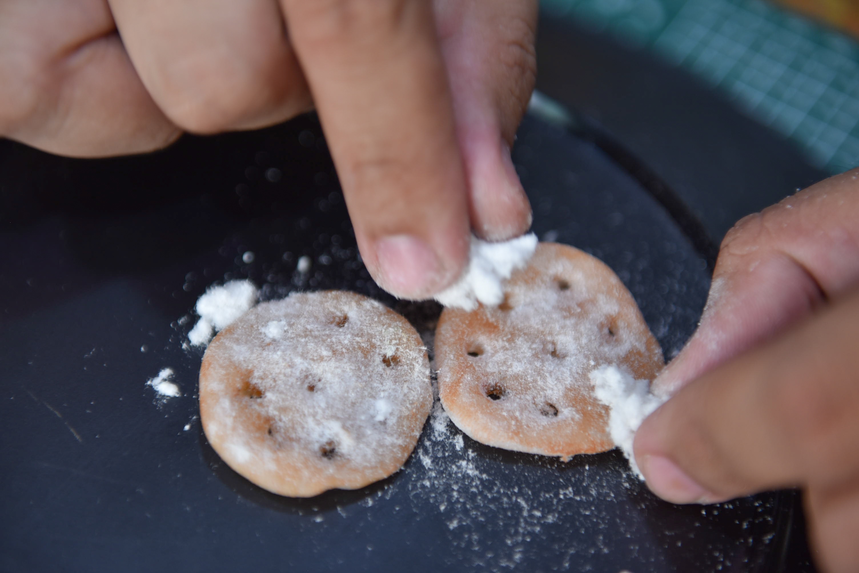 Nguyen Tan Dat uses pulverized paper to create the sugar coating for his clay snacks. Photo: Ngoc Phuong / Tuoi Tre News
