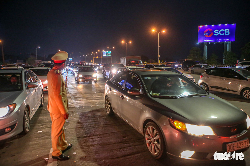 This image shows a traffic police officer regulating traffic on the Phap Van - Cau Gie Expressway part that leads to central Hanoi, Vietnam on February 4, 2022. Photo: Ha Quan / Tuoi Tre
