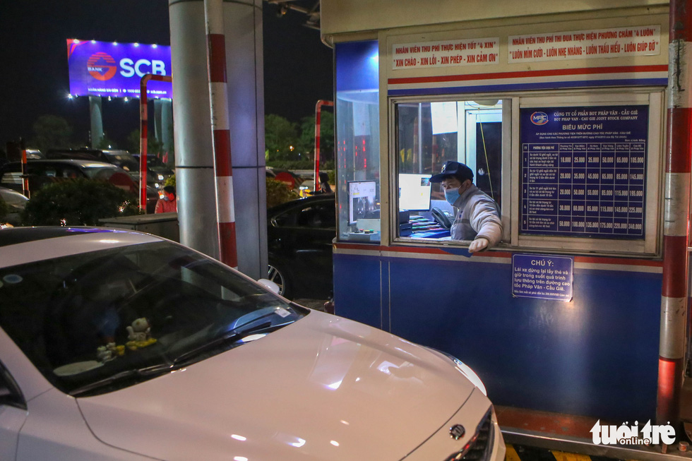 An employee is seen working without respite at a toll booth on the Phap Van - Cau Gie Expressway section that leads to the heart of Hanoi, Vietnam on February 4, 2022. Photo: Ha Quan / Tuoi Tre