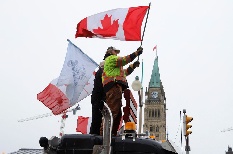 People wave flags on top of a truck in front of Parliament Hill as truckers and their supporters continue to protest against the COVID-19 vaccine mandates in Ottawa, Ontario, Canada, February 6, 2022. Photo: Reuters